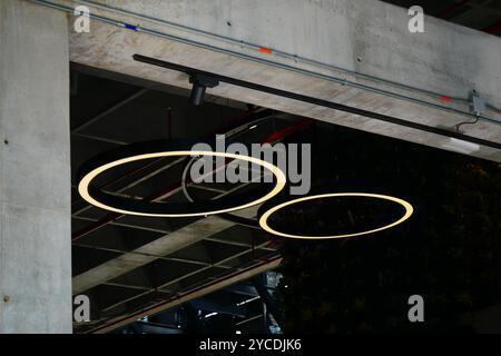 Ein moderner architektonischer Raum mit Hängelampen im industriellen Stil. Das sanfte Leuchten und das elegante Design der Leuchten sorgen für eine minimalistische Ästhetik. Stockfoto