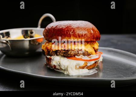 Saftiger Gourmet-Cheeseburger mit frischen Belägen und geschmolzenem Käse, Gourmet-Liebhaber und zwangloses Essen Stockfoto