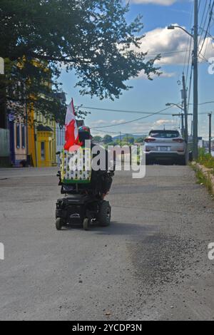 Ältere Frau im Rollstuhl mit kanadischer Flagge. Saint John, New Brunswick, Kanada, Stockfoto