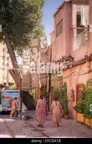 Kashgar, Xinjiang, China - 17. JULI 2023: Uigurische Frauen spazieren durch die Wohngegend der antiken Stadt Kashgar Stockfoto