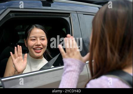 Eine fürsorgliche und freundliche asiatische Mutter verabschiedet sich von ihrer kleinen Tochter, als sie sie morgen früh zur Schule bringt. Familienkonzept Stockfoto