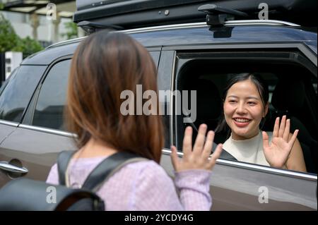 Eine fürsorgliche und freundliche asiatische Mutter verabschiedet sich von ihrer kleinen Tochter, als sie sie morgen früh zur Schule bringt. Familienkonzept Stockfoto