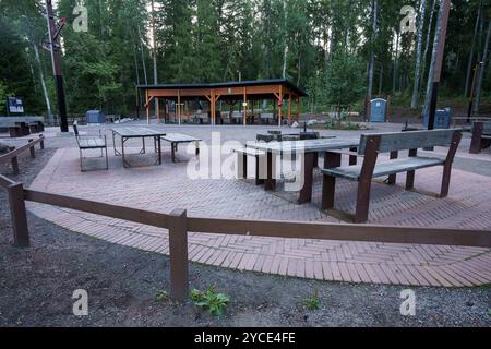 Vantaa, Finnland. August 2024 - Picknickbereich im Freien mit Holztischen und Unterkünften im Erholungsgebiet Kuusijärvi. Stockfoto