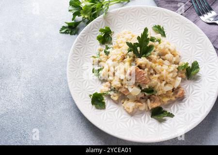 Salat aus gekochtem Reis, rotem Fisch, rosa Lachseiern und Gemüse auf einem Teller Copy Space Stockfoto