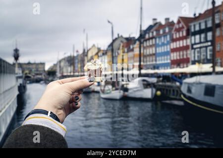 Der Tourist hält ein Stück nationale Bankrechnung für die Nyhavn-Boote Stockfoto