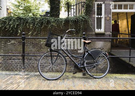 Gouda, Niederlande, 4. August 2016: Fahrrad parkt am Kanal in einer malerischen Straße in der niederländischen Stadt Gouda Stockfoto