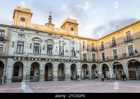 Avila, Spanien, 11. November 2014: Menschen auf dem Rathausplatz nannten Mercado Chico einen bewölkten Tag bei Sonnenuntergang. Die Altstadt und ihre außermaurerischen Kirchen waren es Stockfoto