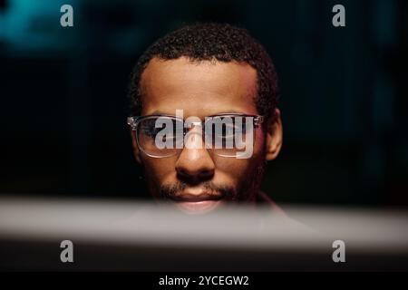 Fokussierter afroamerikanischer Mann, der Brille am Computer trägt Stockfoto
