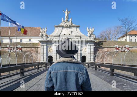 Ein junger Mann mit einem Hut bewundern, eine Festung Gate Eingang. Ein Mann bewundern das 3. Tor der Alba-Carolina Festung in Alba Iulia, Rumänien. Al Stockfoto