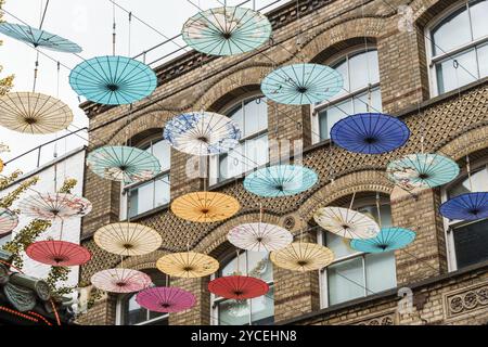 Bunte Regenschirme hängen über der Straße in Chinatown in Soho, London Stockfoto