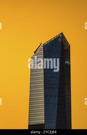 Madrid, Spanien, 17. August 2022: KPMG Tower im Geschäftsviertel Cuatro Torres. Blick bei Sonnenuntergang mit einem dramatischen leuchtenden gelben Himmel. Teleobjektiv, EUR Stockfoto