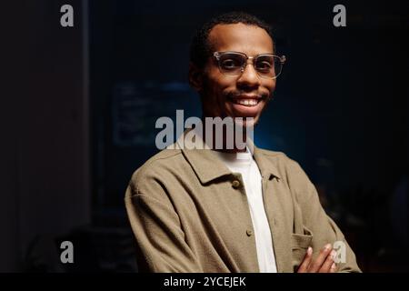 Lächelnder Afroamerikaner mit Brille im Büro Stockfoto
