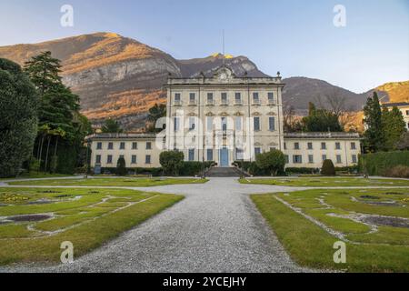 Alte Villa Sola Cabiati in Tremezzo, am Comer See. Lombardei, Italien. Erstaunliche Berg Hintergrund in gelben Strahlen des Sonnenuntergangs Stockfoto