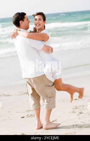 Glückliche junge Paare, die Spaß am Strand Stockfoto