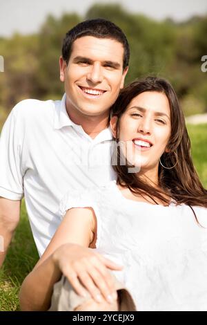 Porträt eines glücklichen jungen Paares, das sitzt und lächelt Stockfoto