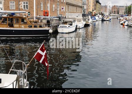 Kopenhagen, Dänemark, 12. August 2016: Hafen von Kopenhagen mit Booten und Schiffen. Dänische Flagge im Vordergrund, Europa Stockfoto