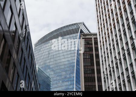London, UK, 25. August 2023: Flacher Blick auf moderne Bürogebäude in der City of London und Reflexionen an der Vorhangfassade. Ansicht gegen Blau Stockfoto