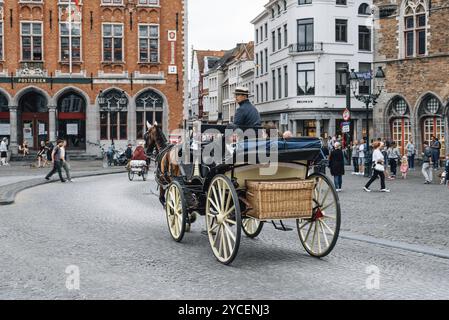 Brügge, Belgien, 29. Juli 2016: Pferdekutsche für Touristen auf dem Marktplatz in Brügge. Das historische Stadtzentrum gehört zum Weltkulturerbe Stockfoto