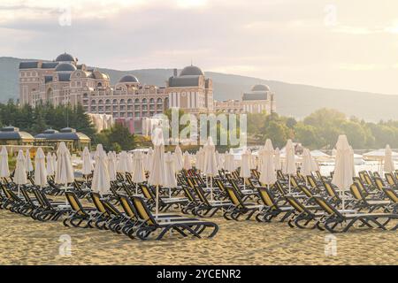 Liegestühle und Sonnenschirme an einem wunderschönen Strand bei Sonnenaufgang in Sunny Beach an der Schwarzmeerküste Bulgariens Stockfoto