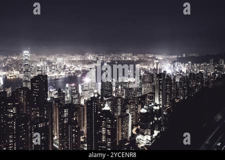 Fantastische Aussicht auf Hongkong, Wolkenkratzer vom Gipfel. Nächtliche Landschaft von Central nach Kowloon von Hongkong. Gefiltert für einen urbanen Look Stockfoto