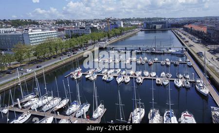 Drohnenblick auf Bassin Vauban und Docks Vaubanat rechts, Fußgängerbrücke im Zentrum und Allee mit Bäumen und weißen Yachten auf Parkplätzen in L Stockfoto