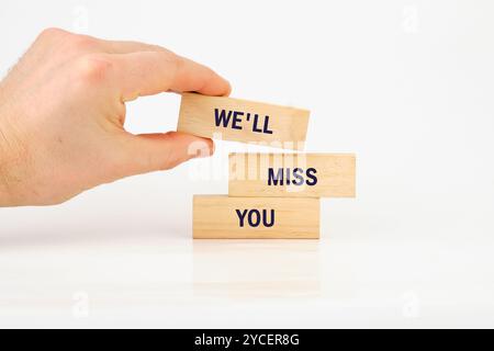Geschäftskonzept. Konzeptionelle Phrase, Wörter, Text, DEN WIR VERMISSEN WERDEN, geschrieben auf Holzstäben, die von Hand auf weißem Hintergrund komponiert wurden. Stockfoto
