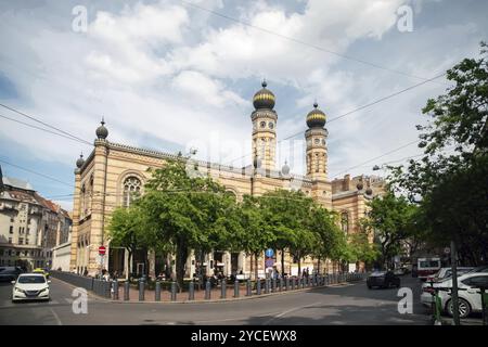 Synagoge in Budapest, verschwommene Bewegung Menschen in erstaunlichen Mai>Autos auf der Straße und auf den Parkplätzen Stockfoto