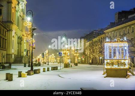 Bald Weihnachten! Ein Wintermärchen, Schnee fällt! Beleuchtet von einigen Figuren aus Lichtern auf der Fußgängerzone Krakowskie Przedmiescie in der Innenstadt von o Stockfoto