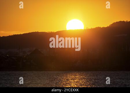 Sonnenuntergang über einer Landschaft mit Kirche und See in warmen Farben, Hoernle, Konstanz, Bodensee, Baden-Württemberg, Deutschland, Europa Stockfoto