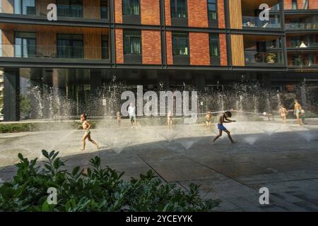 08-27-2022 Warschau POL Neues Wohnviertel neben dem Square WSR in Warschau: kinder laufen im Brunnen, heiße Luft (ca. 29 °C). Verschwommene Bewegungskinder als arti Stockfoto