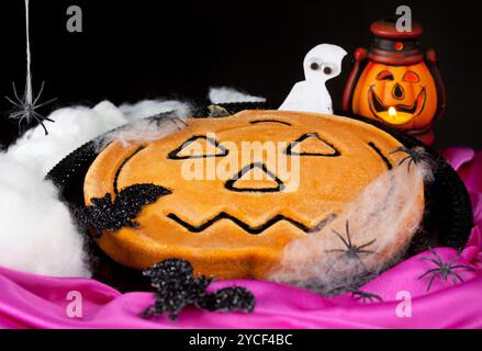 Kürbiskuchen mit Spinnen auf schwarzem Hintergrund Stockfoto