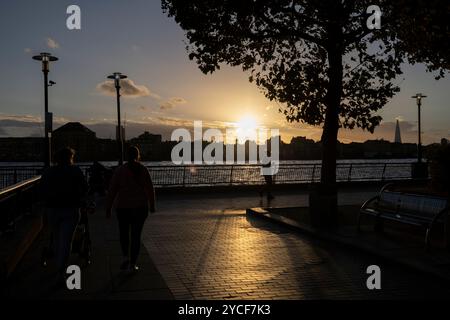 Familienspaziergang bei Sonnenuntergang im Herbst entlang des Flusses Themse Pfade bei Dundee Wharf, Westferry, Docklands, East London, England, UK Stockfoto