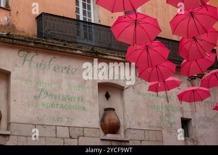 Rote Regenschirme, Regenschirme, hängen zwischen den Häusern in der Parfümstadt Grasse, Provence-Alpes-Cote d'Azur, Frankreich Stockfoto