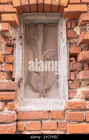 Vergittertes Fenster auf einem baufälligen Haus Stockfoto