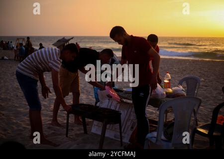 Gaza, Palästina. 16. Mai 2020. Palästinenser genießen den Sonnenuntergang am Meer in Gaza-Stadt. Palästinensern ist es gestattet, während des Ramadan bei Familienversammlungen am Strand ihr iftar- oder Abendmahl zu konsumieren, obwohl im Gazastreifen einige Vorsichtsmaßnahmen getroffen wurden, um die Ausbreitung von COVID-19 zu verhindern. Ausflüge und Picknicks an die Küste und ihre fröhliche Atmosphäre bieten den Gazastreibern eine gewisse Erleichterung von ihren Sorgen über die hohe Armutsrate und Arbeitslosigkeit sowie die häufigen Stromausfälle in der belagerten palästinensischen Enklave Stockfoto