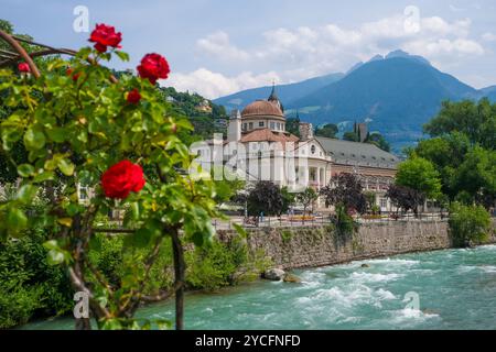 Meran, Südtirol, Italien, Kurhaus an der Passer-Promenade in der Altstadt. Vorne rote Rosen auf der Thermalbrücke. Stockfoto