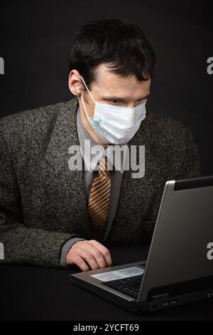 Mann in medizinischer Maske diagnostiziert Computer Stockfoto