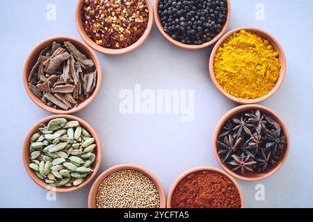 Gewürze, Zutaten und Kräuterkreis im Studiohintergrund zum Kochen und Mockup von oben. Vielfalt, Bio-Gewürze und Geschmack Stockfoto