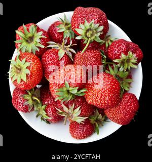 Erdbeeren auf Teller auf schwarzem Hintergrund Stockfoto