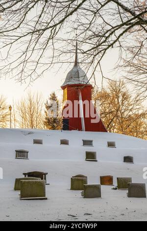 Glockenturm auf einem Hügel auf einem Friedhof an einem schneebedeckten Wintertag Stockfoto