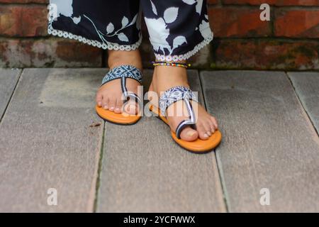 Eine Frau, die Sandalen mit Blumenmuster trägt Stockfoto