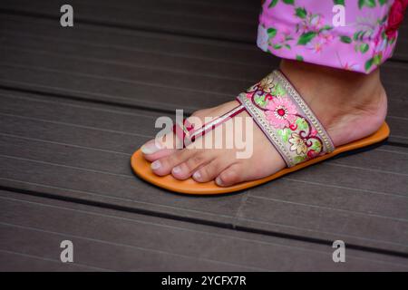 Eine Frau, die Sandalen mit Blumenmuster trägt Stockfoto