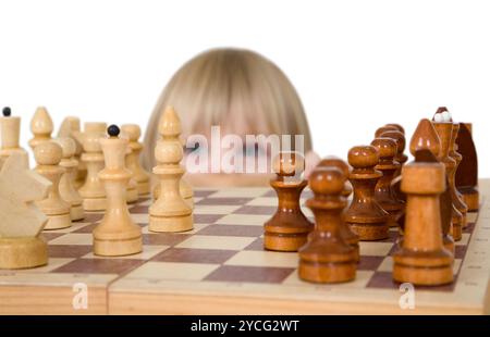 Kleines Mädchen sucht Schach auf dem weißen Hintergrund Stockfoto