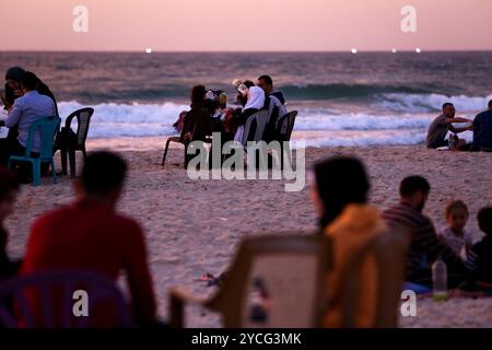 Gaza, Palästina. 16. Mai 2020. Palästinenser genießen den Sonnenuntergang am Meer in Gaza-Stadt. Palästinensern ist es gestattet, während des Ramadan bei Familienversammlungen am Strand ihr iftar- oder Abendmahl zu konsumieren, obwohl im Gazastreifen einige Vorsichtsmaßnahmen getroffen wurden, um die Ausbreitung von COVID-19 zu verhindern. Ausflüge und Picknicks an die Küste und ihre fröhliche Atmosphäre bieten den Gazastreibern eine gewisse Erleichterung von ihren Sorgen über die hohe Armutsrate und Arbeitslosigkeit sowie die häufigen Stromausfälle in der belagerten palästinensischen Enklave Stockfoto