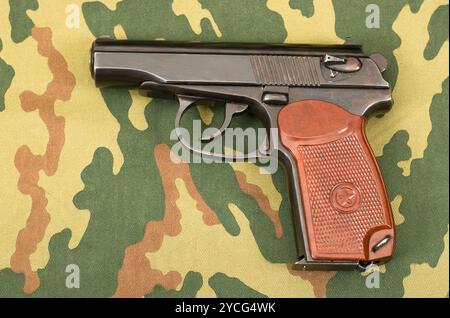 Russische 9-mm-Pistole PM auf Tarnhintergrund Stockfoto