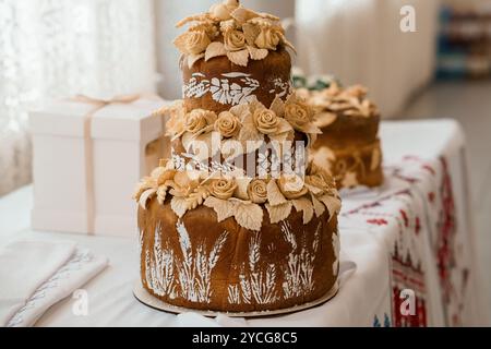 Eleganter dreistöckiger Hochzeitstorte mit Blumenschmuck. Stockfoto