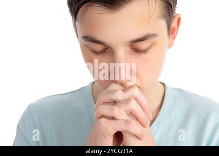 Ein Junge sitzt still in Nachsicht, tiefem Denken, Meditation oder schweigendem Gebet Stockfoto