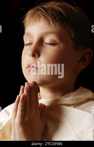 Kind mit Händen zusammen im Gebet Stockfoto