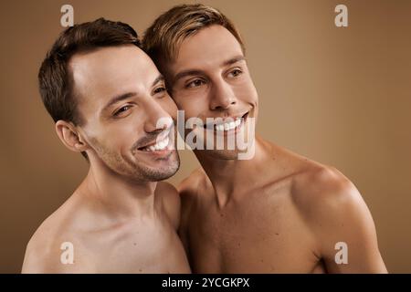 Zwei junge Männer lächeln herzlich und nehmen ihre Liebe und ihr Glück in gemütlicher Umgebung wahr. Stockfoto