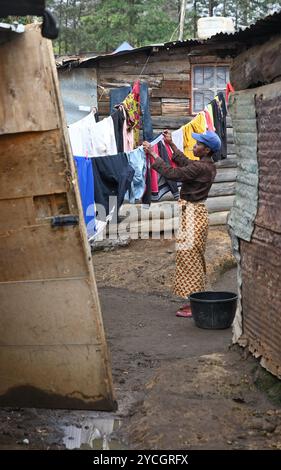 NAIROBI SLUM KIBERA, KENIA, AFRIKA - 18. NOVEMBER 2022: Slumbewohner hängen frisch gewaschene Wäsche an einem Seil. Kenia, Afrika Stockfoto